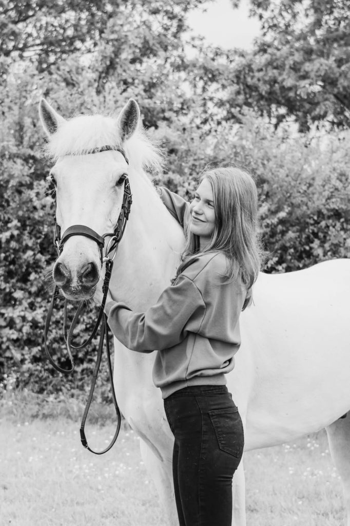 Black and white equestrian photo of a girl and her grey connemara horse