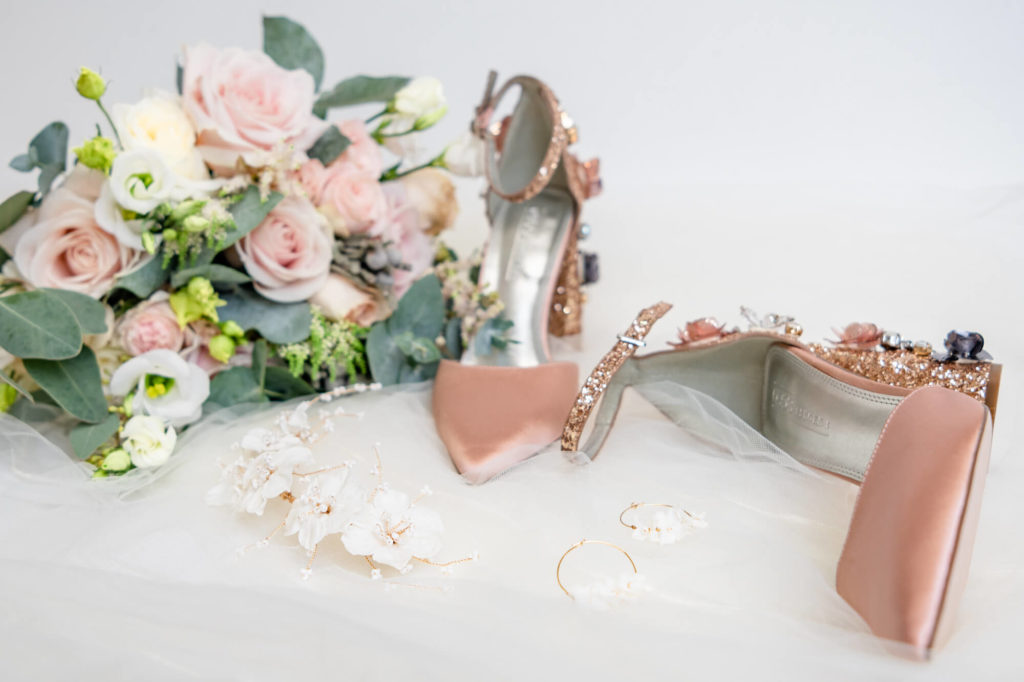 Elegant and feminine wedding details flatlay with pink shoes and roses