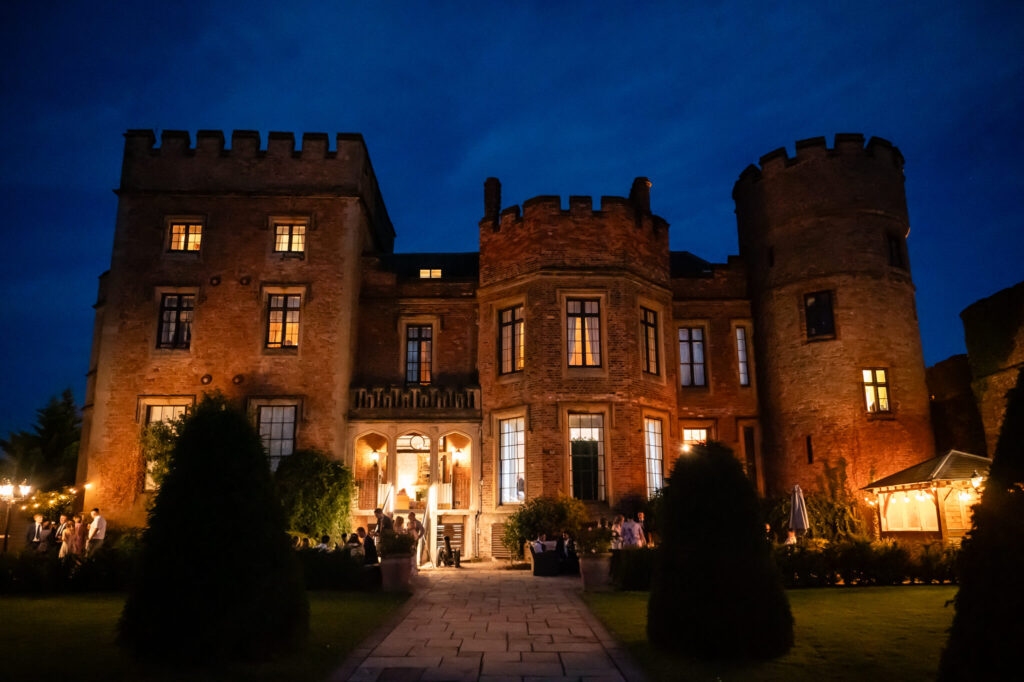 The outside of Rowton Castle wedding venue lit up at night