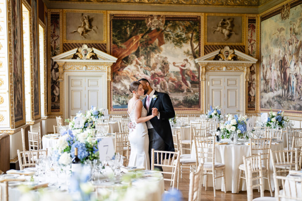 Stowe House state dining room. A newly married couple standing among their tables with blue and white flowers