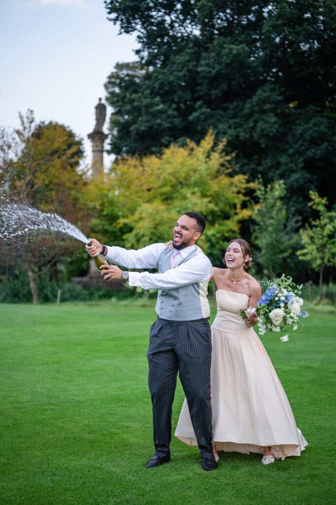 Champagne spray at a Stowe House wedding. Chloe Bolam Photography